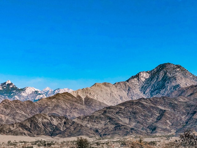Photo of the Afghanistan town of Jalalabad with mountains in the background, taken on 23 February 2024 by Unsplash user Ahmad Shahid.